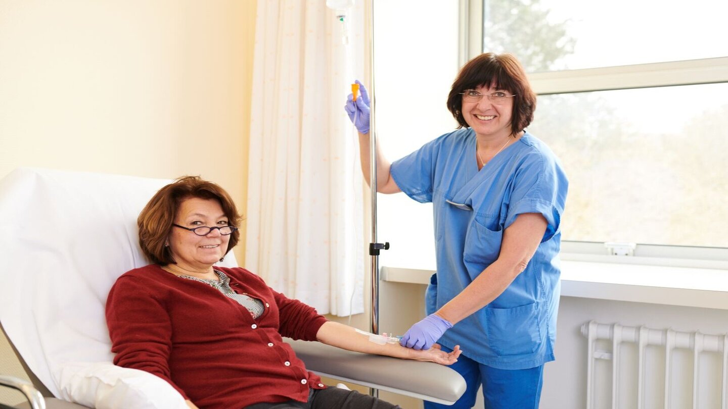 Pflegerin bei sitzender Patientin